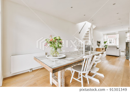 Interior of contemporary kitchen with stylish black cupboards and appliances near dining area in contemporary apartment 91301349