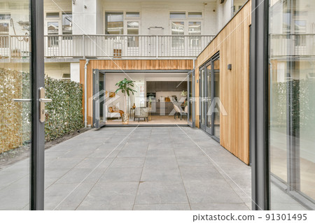 Neat paved patio with sitting area and small garden near wooden fence Neat paved patio with sitting area and small garden near wooden fence 91301495
