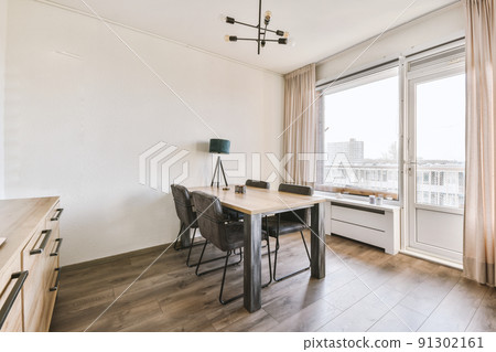 Interior of living room with comfortable sofa and TV against windows in contemporary apartment 91302161