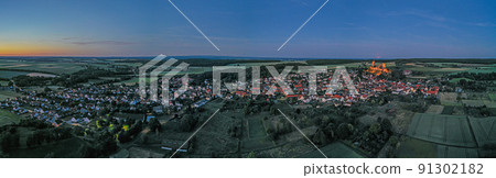 Drone image of Muenzenberg with illuminated castle ruins in Germany Drone image of Muenzenberg with illuminated castle ruins in Germany 91302182