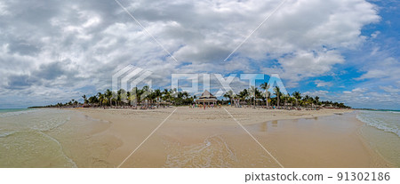 Panorama over a tropical beach taken from the water during the day with sunshine Panorama over a tropical beach taken from the water during the day with sunshine 91302186