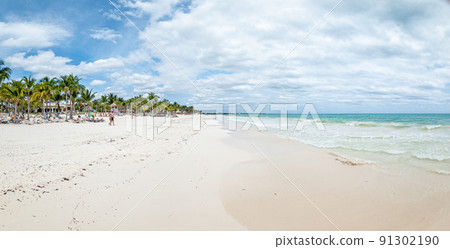 Panorama over a tropical beach taken from the water during the day with sunshine Panorama over a tropical beach taken from the water during the day with sunshine 91302190