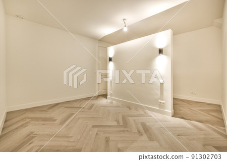 Interior of empty modern apartment with geometric design with entrance door and white walls and parquet floor illuminated with lamp 91302703
