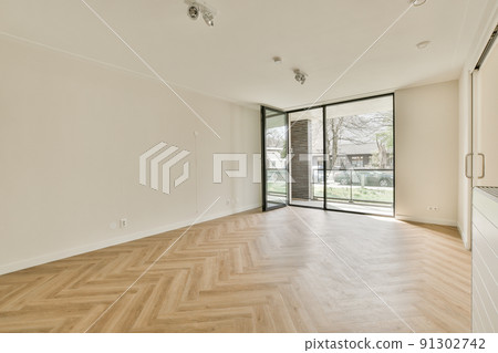 Spacious bright empty room with panoramic windows and parquet floor Spacious bright empty room with panoramic windows and parquet floor 91302742