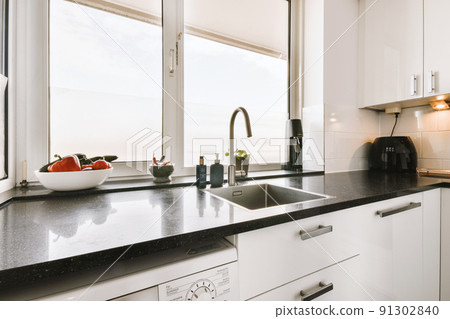 Modern home kitchen interior design in loft style apartment with white furniture and appliances 91302840