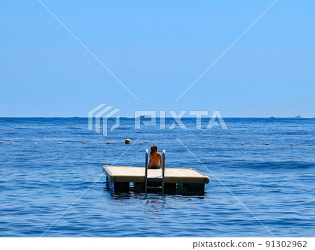法國蔚藍海岸埃茲,漂浮在海面上的漂浮物上的女人 法國蔚藍海岸埃茲,漂浮在海面上的漂浮物上的女人 91302962