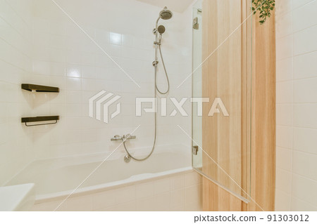 Bright bathroom with wooden partition and bathtub Bright bathroom with wooden partition and bathtub 91303012
