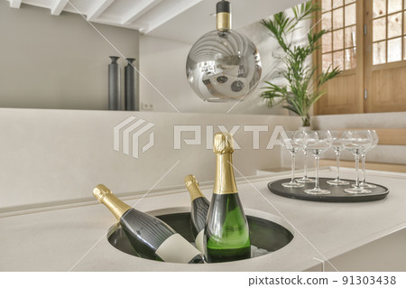 Cozy spacious and bright dining area with a vintage bottles of champagne 91303438
