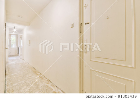 Interior of modern flat in minimal style with narrow empty corridor illuminated by lamps 91303439