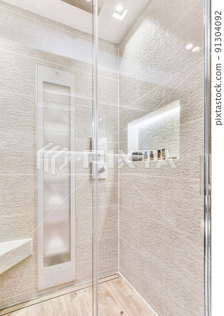 Sink base cabinet and mirror cabinet in white tiled bathroom with wall hung toilet 91304092