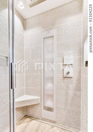 Sink base cabinet and mirror cabinet in white tiled bathroom with wall hung toilet Sink base cabinet and mirror cabinet in white tiled bathroom with wall hung toilet 91304229