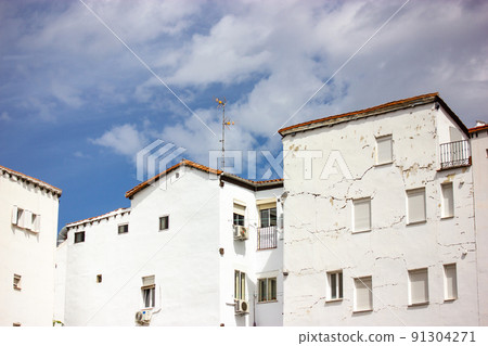 Front view of old residential white houses against blue sky. Old town postcard. 91304271
