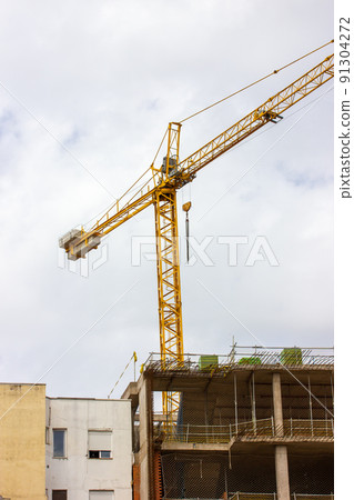 Facade of residential multistory panel building. Scaffolding, construction crane Facade of residential multistory panel building. Scaffolding, construction crane 91304272
