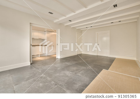 Interior of empty modern apartment with geometric design with entrance door and white walls and tiled floor illuminated with lamp Interior of empty modern apartment with geometric design with entrance door and white walls and tiled floor illuminated with lamp 91305365
