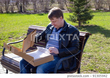 Blond man happily considers his purchase, modern laptop Blond man happily considers his purchase, modern laptop 91305942
