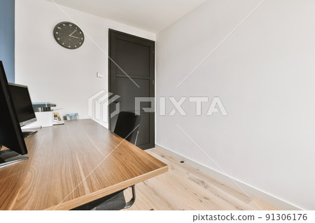 Interior of light home office with wooden desk and shelf rack near window with curtains Interior of light home office with wooden desk and shelf rack near window with curtains 91306176