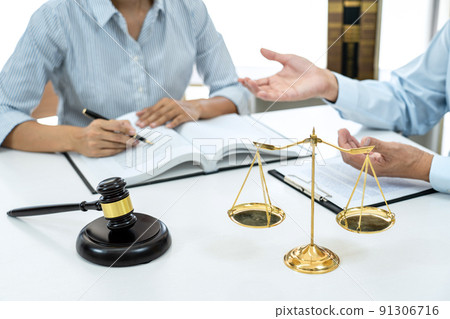 Male lawyer or notary consulting and discussion to businesswoman client in the office, Judge gavel with scales of justice Male lawyer or notary consulting and discussion to businesswoman client in the office, Judge gavel with scales of justice 91306716