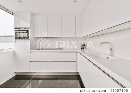 Modern home kitchen corner interior design with white cupboards and cabinets and sink and stove in contemporary apartment Modern home kitchen corner interior design with white cupboards and cabinets and sink and stove in contemporary apartment 91307106