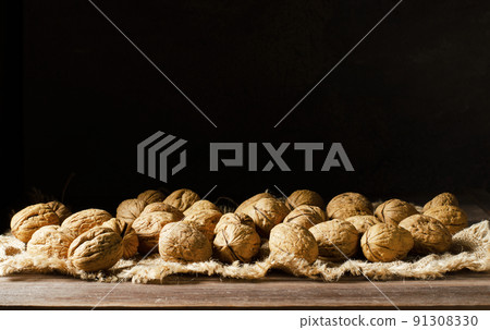 Walnuts on a dark brown wooden background. Nuts are a source of vitamins and vegetable protein. Copy space 91308330