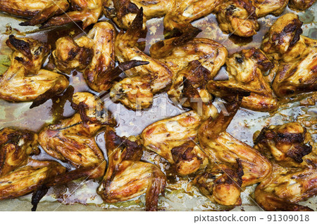Close up barbecue grilled chicken wings in a cast-iron frying pan with assorted sauces on a stone background. Top view. Flat lay. Crispy tasty snack for beer. Closeup Close up barbecue grilled chicken wings in a cast-iron frying pan with assorted sauces on a stone background. Top view. Flat lay. Crispy tasty snack for beer. Closeup 91309018