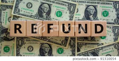 Refund symbol. Concept word 'refund' on wooden cubes on a beautiful background from dollar bills. Business and refund concept. 91310054