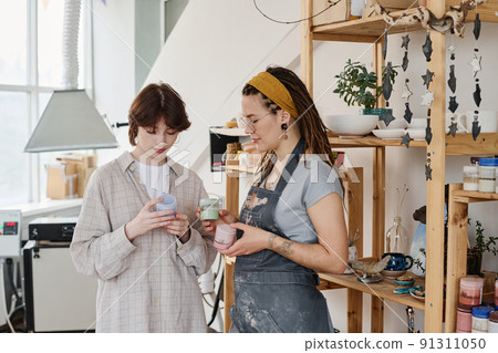 Young female client choosing gouache for painting handmade earthenware Young female client choosing gouache for painting handmade earthenware 91311050