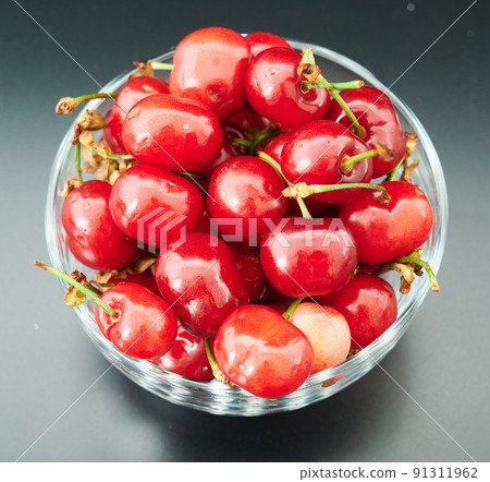 fresh cherries in a glass plate on a shady background 91311962