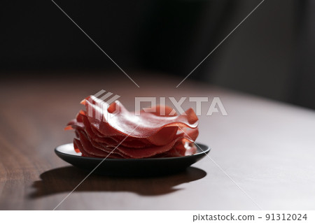 saucer with this slices of bresaola on walnut wood table saucer with this slices of bresaola on walnut wood table 91312024