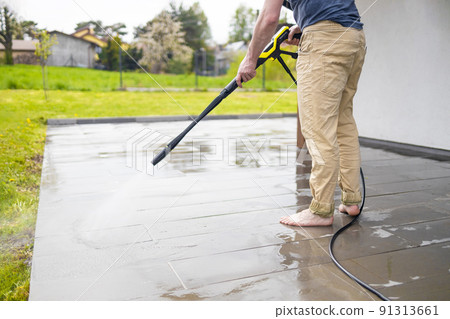 Pressure washer cleaning machine on wet concrete floor near the house build, cleaning terrace with a power washer 91313661