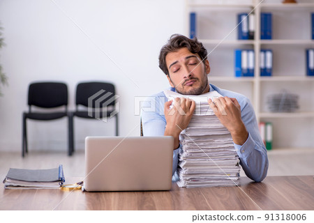Young male employee and too much work in the office 91318006