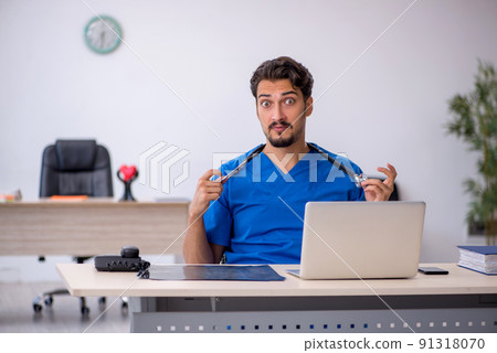 Young male doctor working in the clinic Young male doctor working in the clinic 91318070