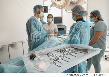 Concentrated surgical team working with a patient in an operation room 91318983