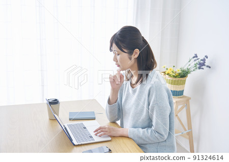 A woman in trouble in front of a laptop in the living room 91324614