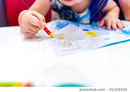 Kid play, study and learn how to color and draw the crayon color in to the paper with her parents. 91326584