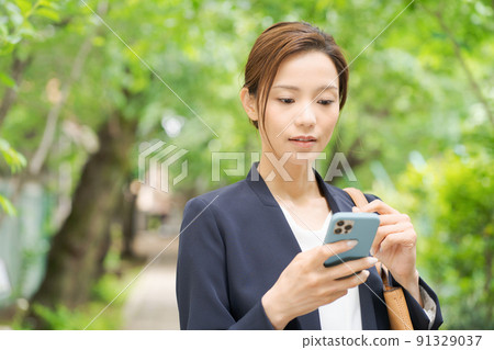 一個有智能手機的女人，新鮮的綠色 91329037