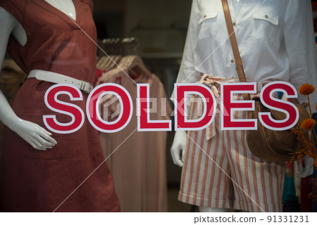discount sign "SOLDES " in french, the traduction of (sales ) on window in french fashion store showroom on summer clothes background discount sign "SOLDES " in french, the traduction of (sales ) on window in french fashion store showroom on summer clothes background 91331231