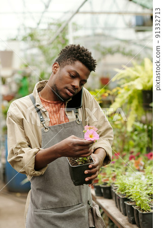 Florist telling about flower by phone in hothouse 91332713