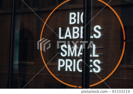 BIG LABELS SMALL PRICES inscription in neon lights at night. Electric sign at night nightlife concept. Modern fluorescent life style luminescent. LED light sign text  91333219