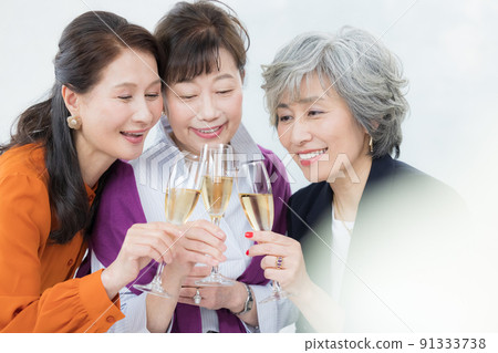 Senior woman toasting with champagne 91333738