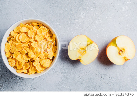 Corn flakes in a blue Cup and Apple slices. Useful Breakfast in the morning. Copy space Corn flakes in a blue Cup and Apple slices. Useful Breakfast in the morning. Copy space 91334370