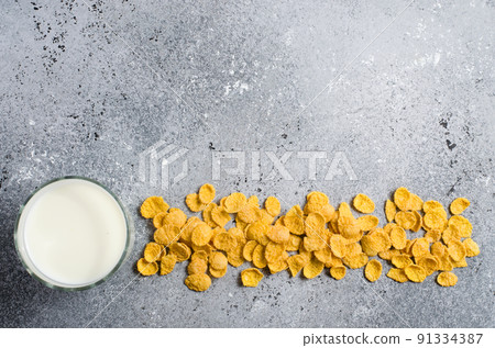 Corn flakes on a concrete background and milk in a glass. Flat top view. Copy space 91334387
