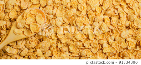 Yellow background of corn flakes. Wooden spoon. Healthy and nutritious Breakfast. Copy space 91334390