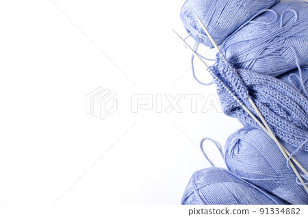Balls of blue yarn and knitting needles. White background. Copy space. The concept of women 's needlework 91334882
