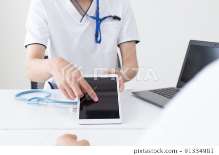 Female healthcare worker explaining on a tablet Female healthcare worker explaining on a tablet 91334981