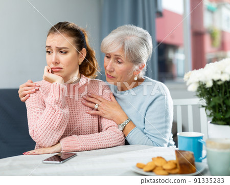 Senior mother encouraging her upset daughter 91335283