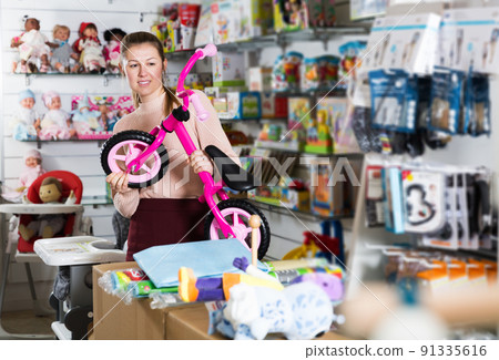 Female buyer choosing clothes for infant Female buyer choosing clothes for infant 91335616