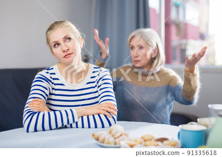 Elderly mother is unhappy with her adult daughter during domestic quarrel Elderly mother is unhappy with her adult daughter during domestic quarrel 91335618