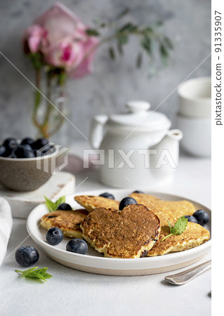 Pancakesheart shaped with fresh blueberries, Morning breakfast, delicious vegan pancakes. Bright background. Pancakesheart shaped with fresh blueberries, Morning breakfast, delicious vegan pancakes. Bright background. 91335907