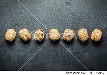 Walnuts on a dark concrete background. Nuts are a source of vegetable protein and vitamins. Flat top view, copy space. Walnuts on a dark concrete background. Nuts are a source of vegetable protein and vitamins. Flat top view, copy space. 91335957