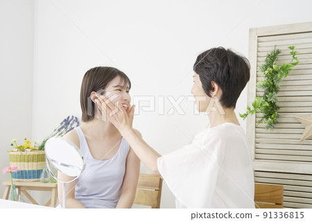 Daughter and mother doing skin care in the living room Daughter and mother doing skin care in the living room 91336815
